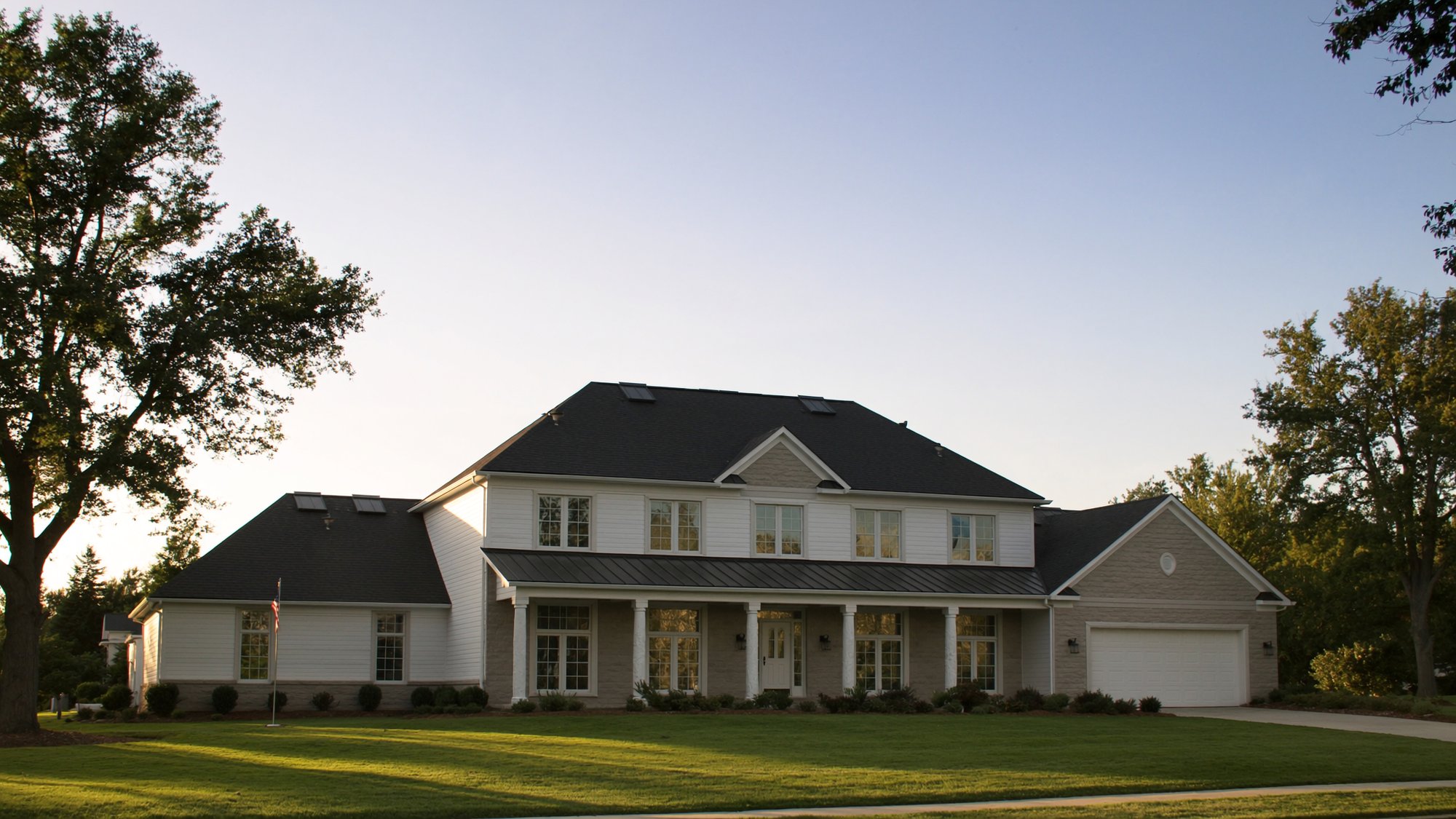Newly installed dark architectural shingle roof on a Midwest home at golden hour