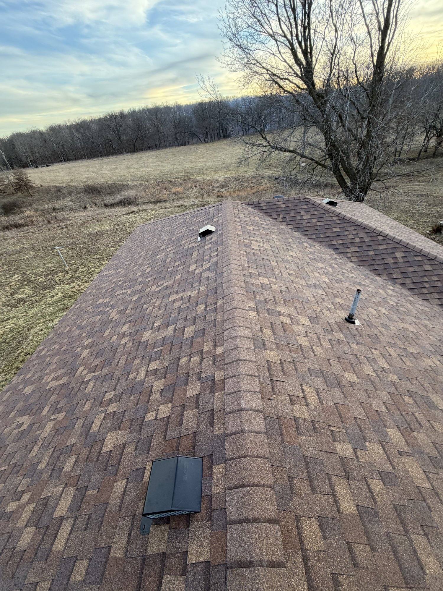 Roofing professional precisely placing architectural shingles — close-up of craftsmanship